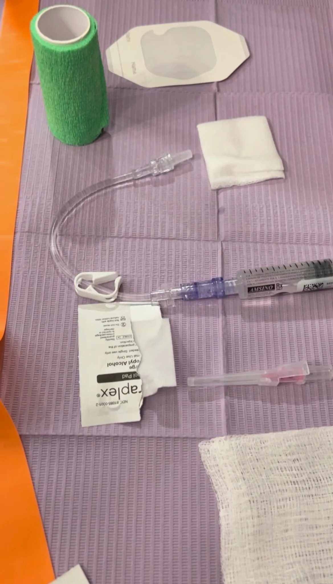 Single-use line and dressing supplies laid out on a clinical drape